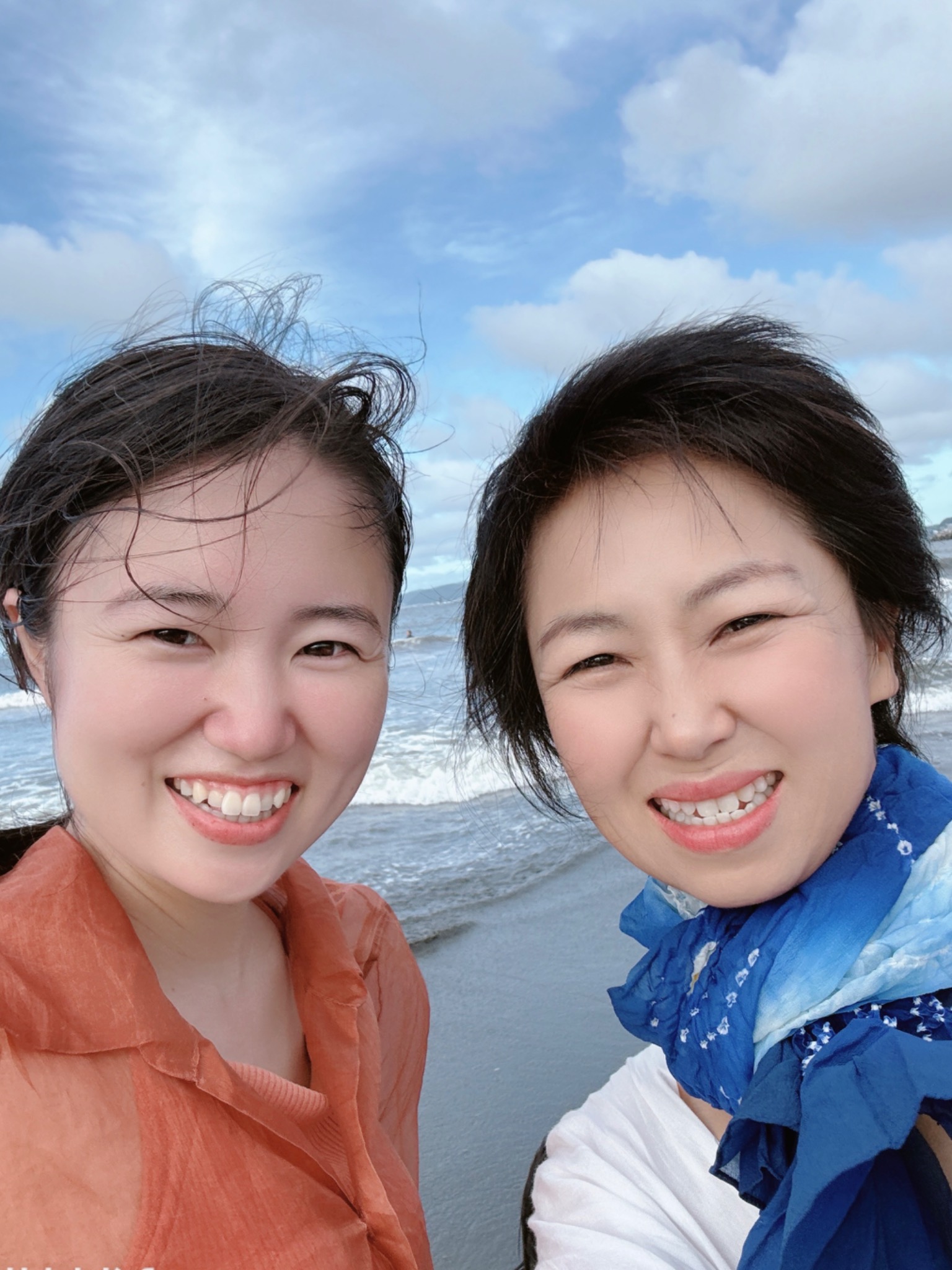 海辺で松本志摩と参加者が一緒に微笑む、継続プログラムのリアルな交流の様子